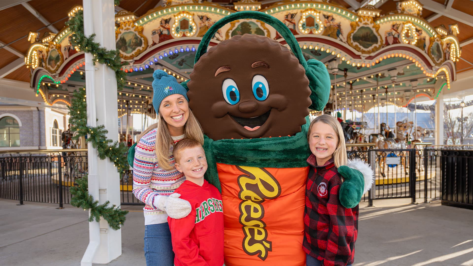 Family Smiling With Reeses Character Dressed For Holidays Hersheypark