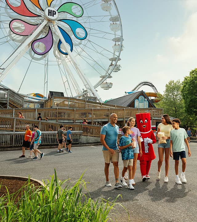 family-walking-with-twizzlers-character-hersheypark-ferris-wheel-in-background.jpg