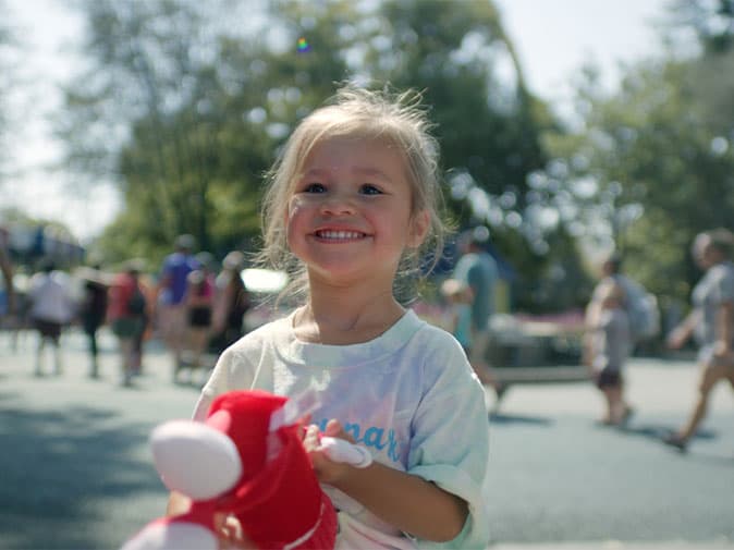 little girl smiling holding twizzlers plush hersheypark
